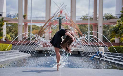 Une femme devant une fontaine